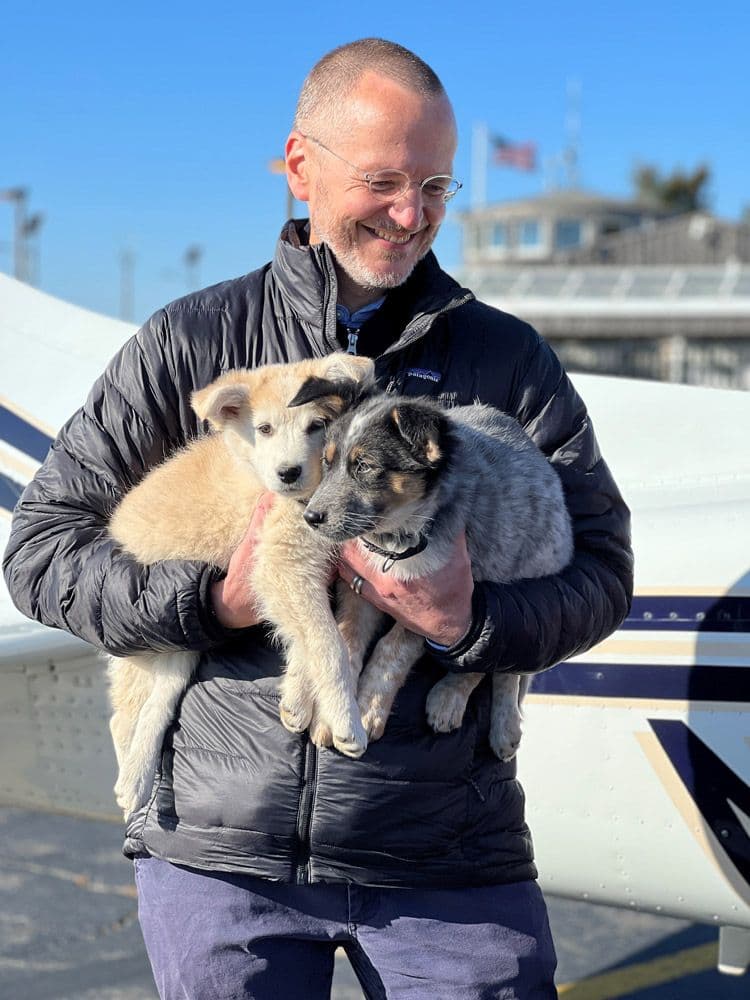 ARF's Scott Howe with two of Zia's nine puppies.